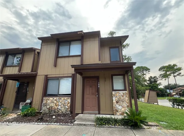Two-story townhome with a covered front entry, attractive stone accents, and well-maintained landscaping, creating a welcoming first impression.
