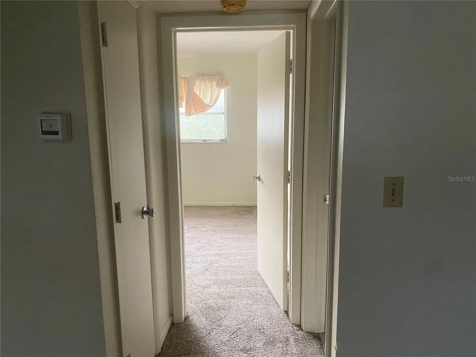 Small hallway leading to the bathroom (on the right) a linen closet (on the left) and into the bedroom (straight ahead)