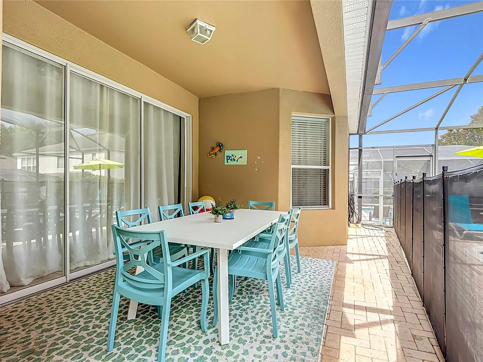 Covered lanai with outdoor dining overlooking the private screened pool and spa.
