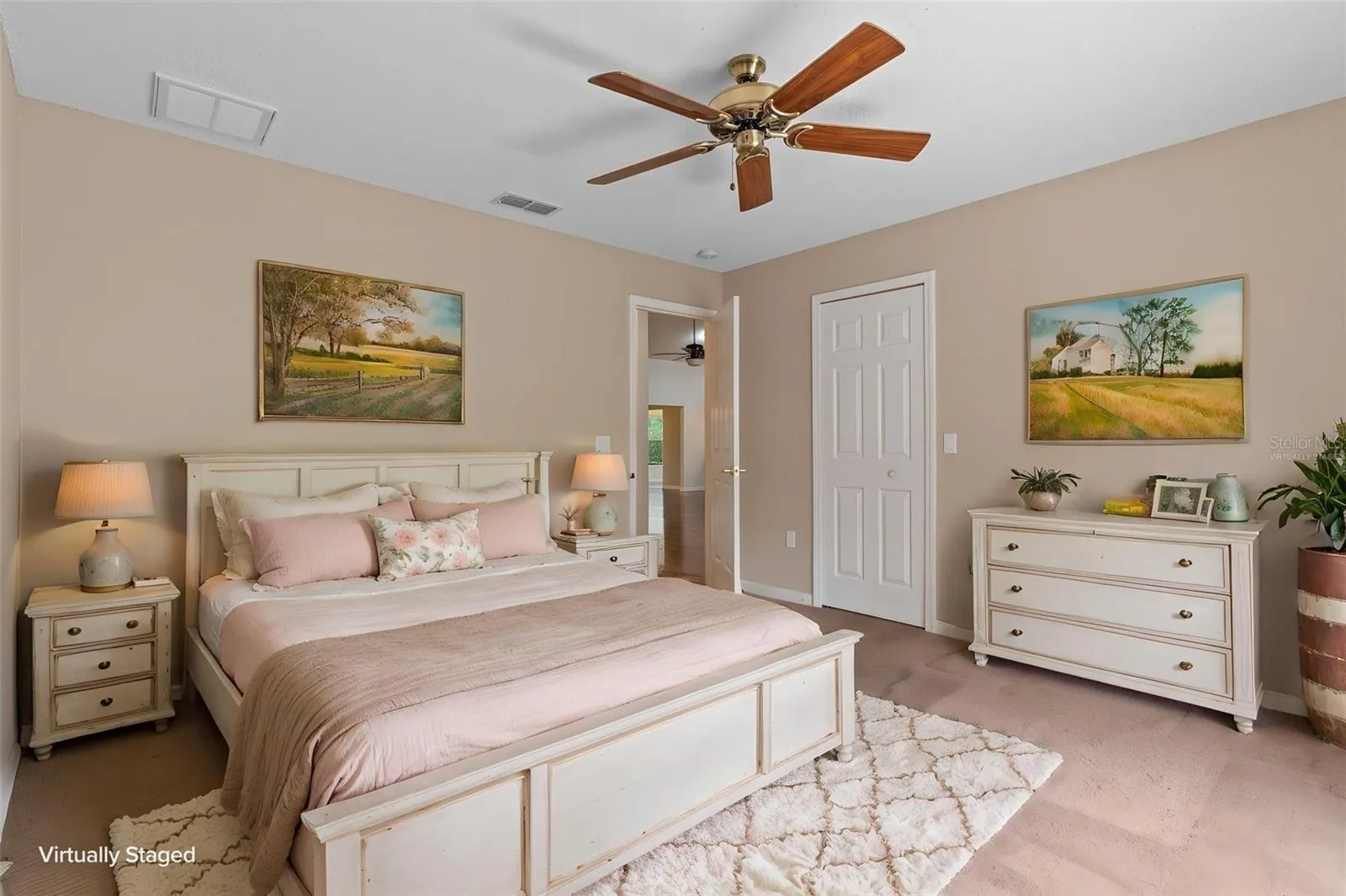 Guest bedroom positioned opposite the primary suite in the split-bedroom floor plan. Virtually staged.