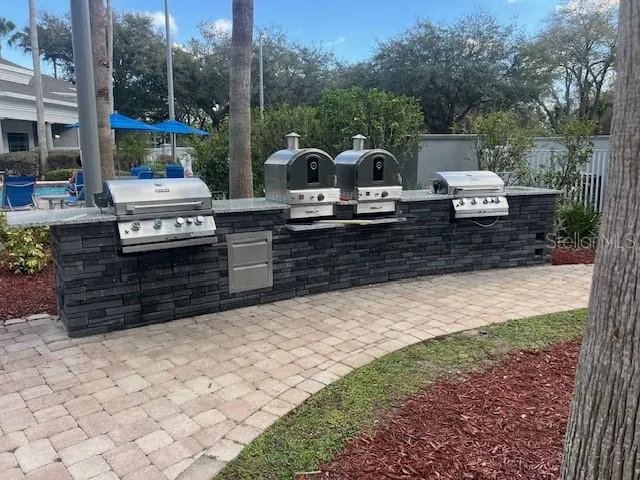 Outside kitchen with a grill and pizza ovens
