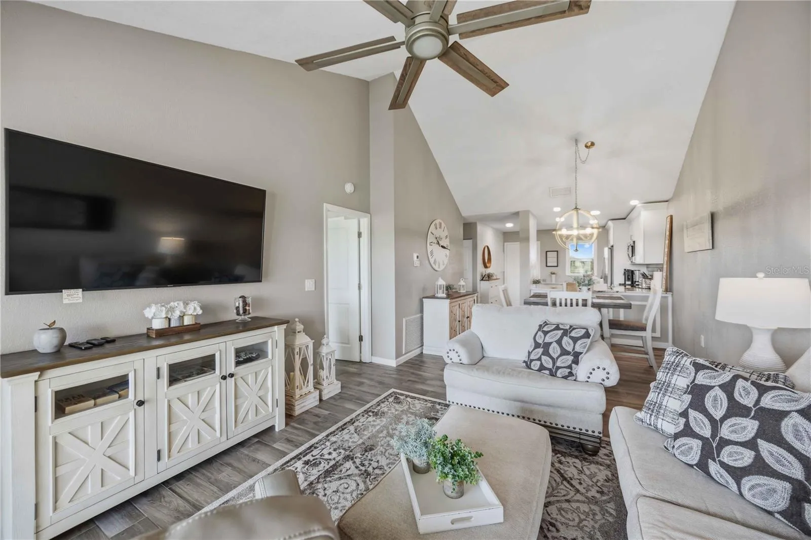 Spacious living area offers an airy feel with vaulted ceilings and large glass doors framing the view.