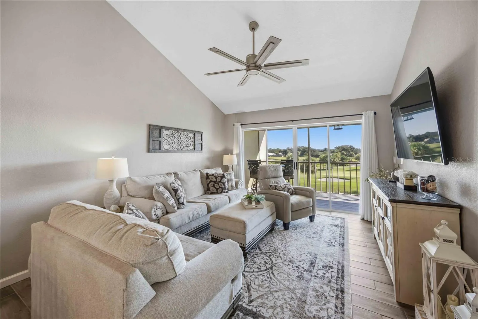 Comfortable living room features a soaring vaulted ceiling, abundant natural light and a beautiful outdoor backdrop.