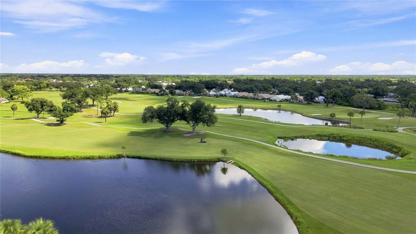 Sweeping aerial captures lush fairways, mature landscaping and sparkling ponds throughout the surrounding area.