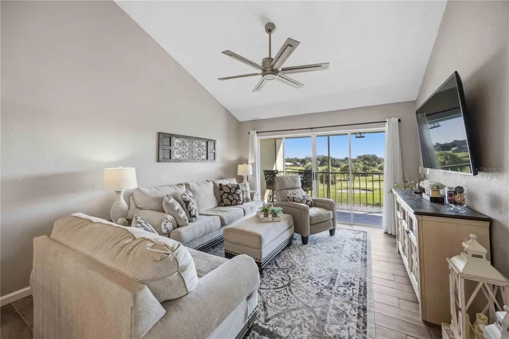 Comfortable living room features a soaring vaulted ceiling, abundant natural light and a beautiful outdoor backdrop.