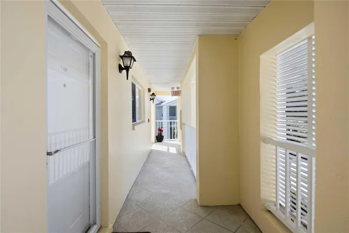 Bright, covered exterior corridor leading to the residence.