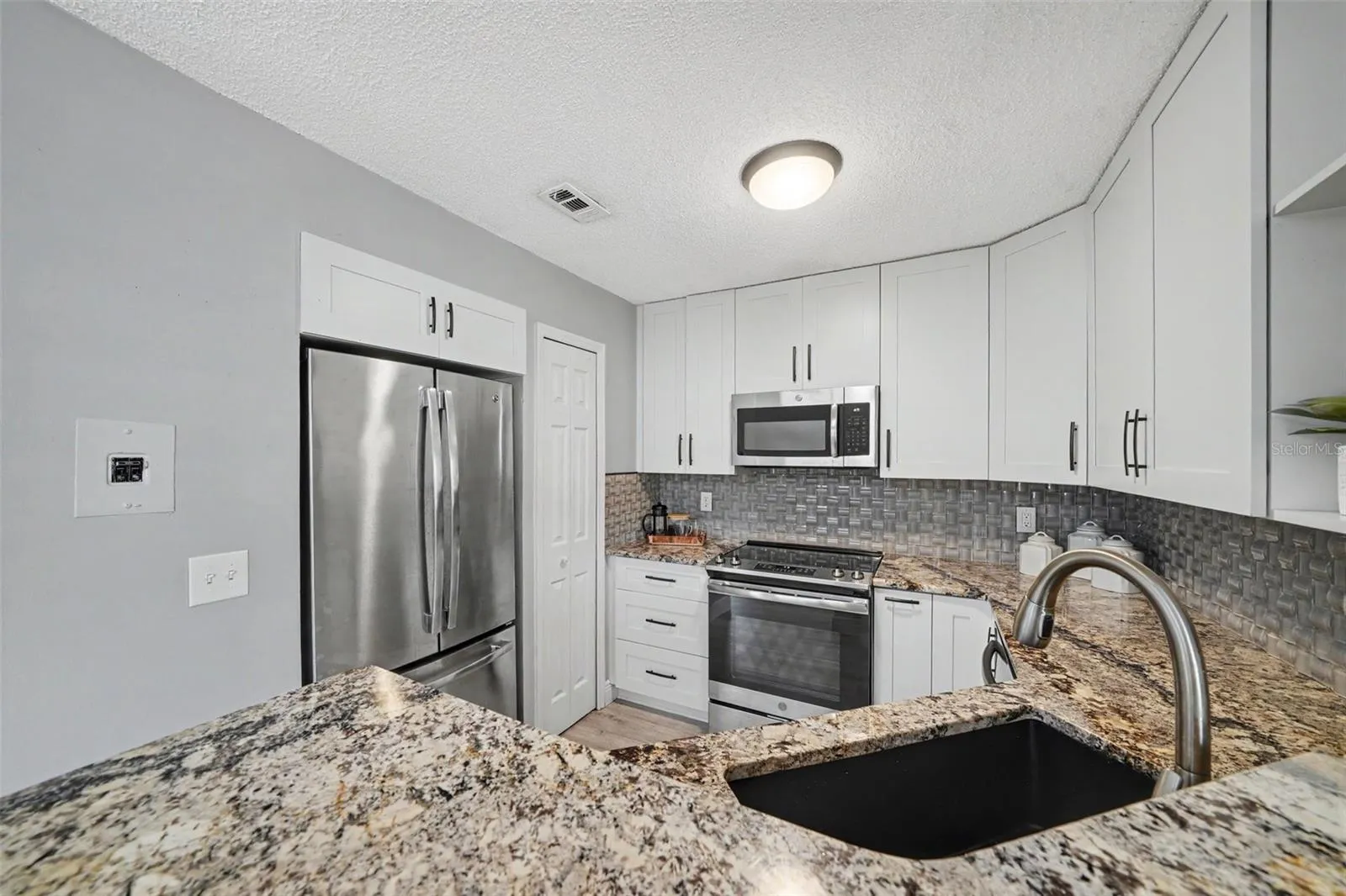 Granite counters, wood cabinets, stainless appliances and excellent storage