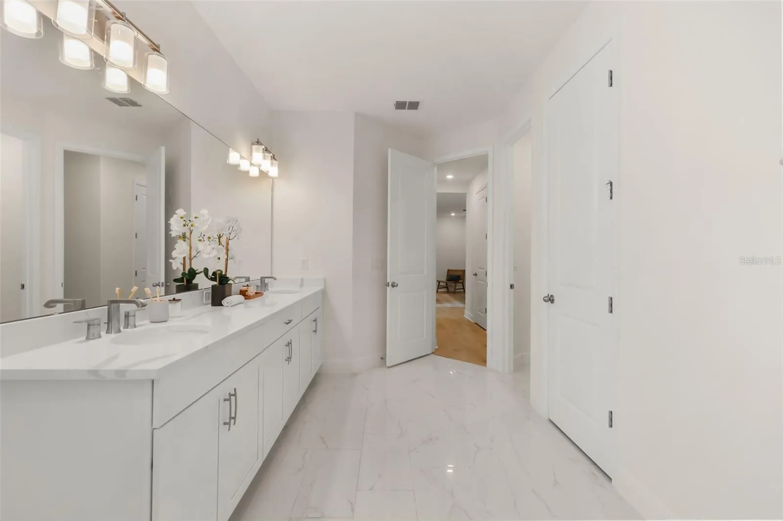 Luxurious primary bathroom with shower, dual vanity, soaker tub, and water closet