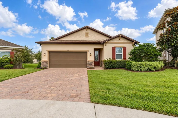 Front exterior with paver driveway, stone accents and two-car garage.