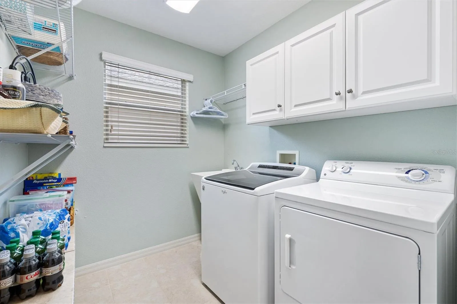 Inside laundry room with cabinets and storage shelves