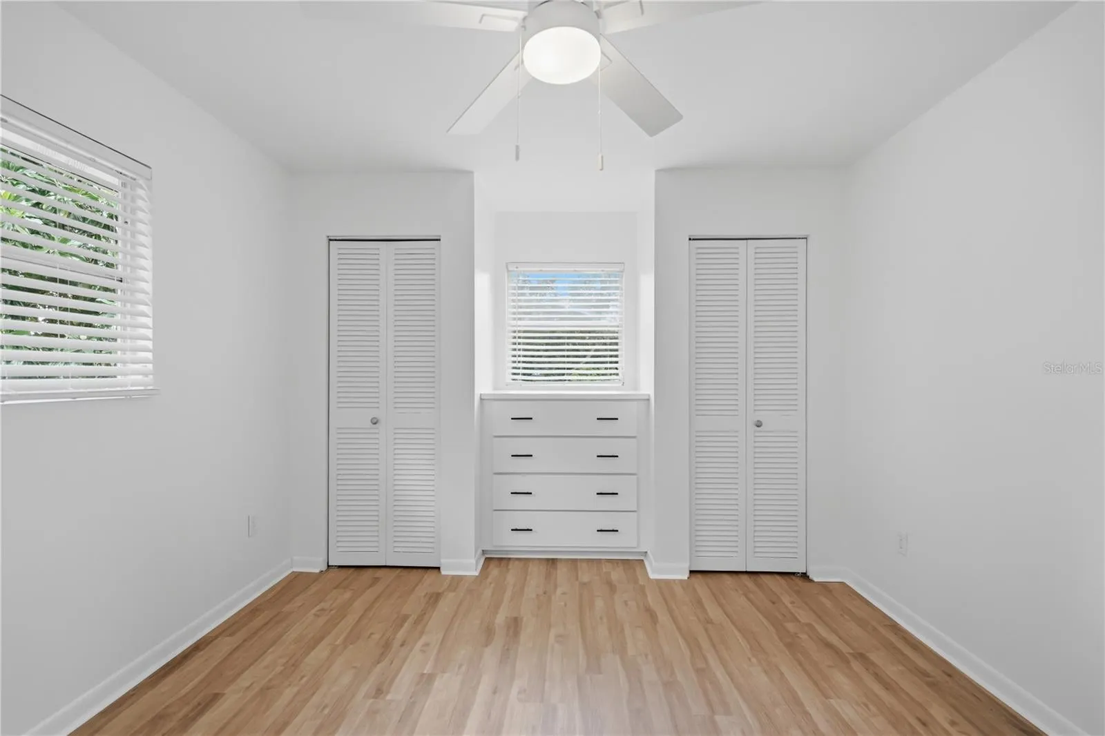 PRIMARY BEDROOM WITH BUILT IN DRESSER AND CLOSETS