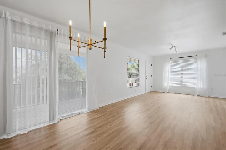 DINING AREA LOOKING AT LIVING ROOM AND OUTDOOR PORCH