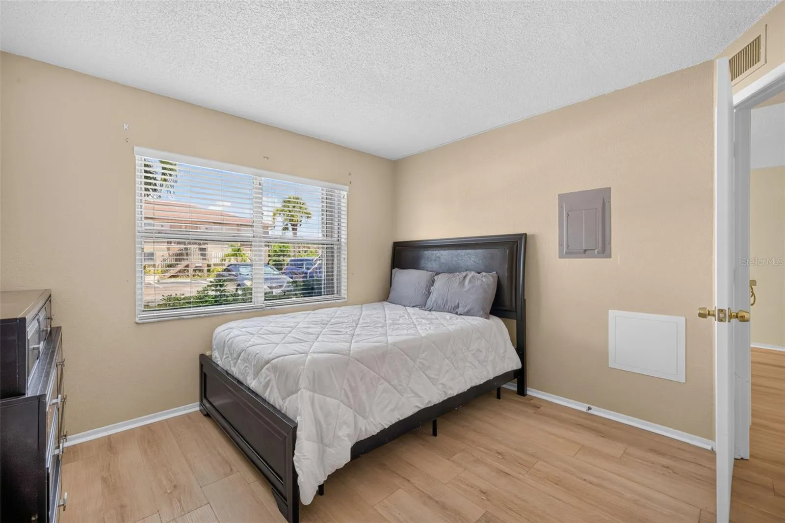 Bedroom 2 with Lament Wood Like Flooring and Window and Window Treaments