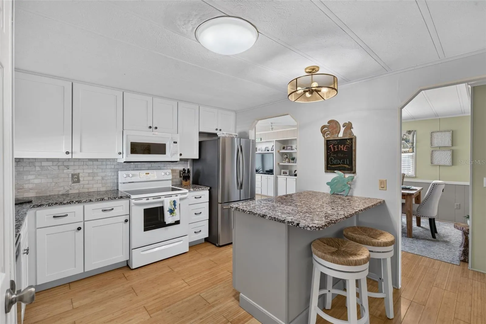 Updated kitchen with island, with open access leading to dining and living room
