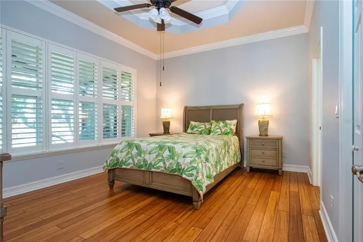 Primary Bedroom-coffered ceiling, plantation shutters,wood flooring