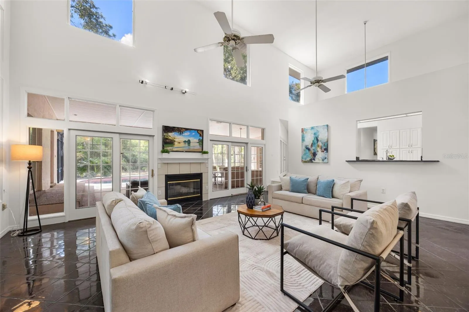 Family room with views of lanai through the double sliders. Check out those fixed widows that draw in the natural sunlight. There's also a view into your kitchen through the bar ledge.