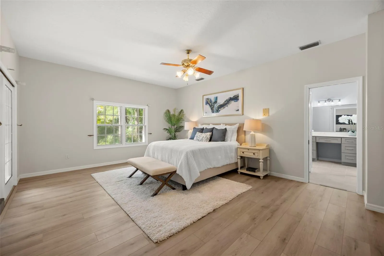 Primary bedroom with sliders to lanai, sitting area and a private remodeled en suite bath.