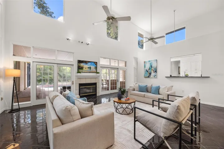 Family room with views of lanai through the double sliders. Check out those fixed widows that draw in the natural sunlight. There's also a view into your kitchen through the bar ledge.