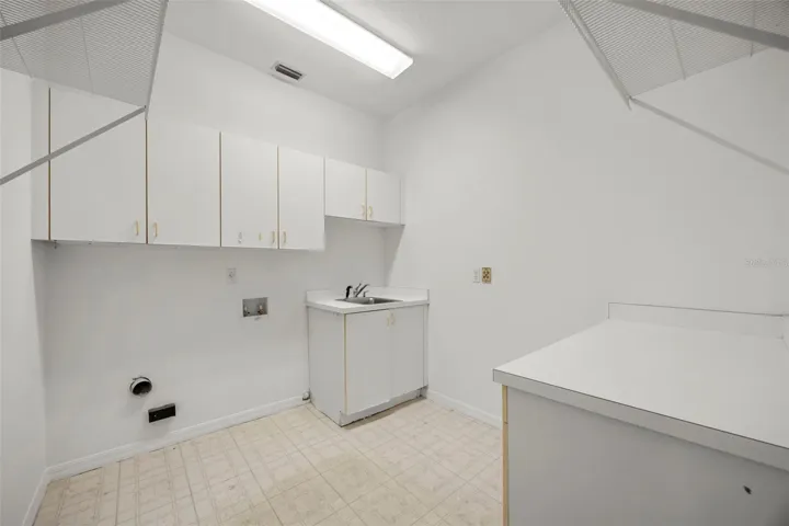 Indoor laundry with cabinets and sink