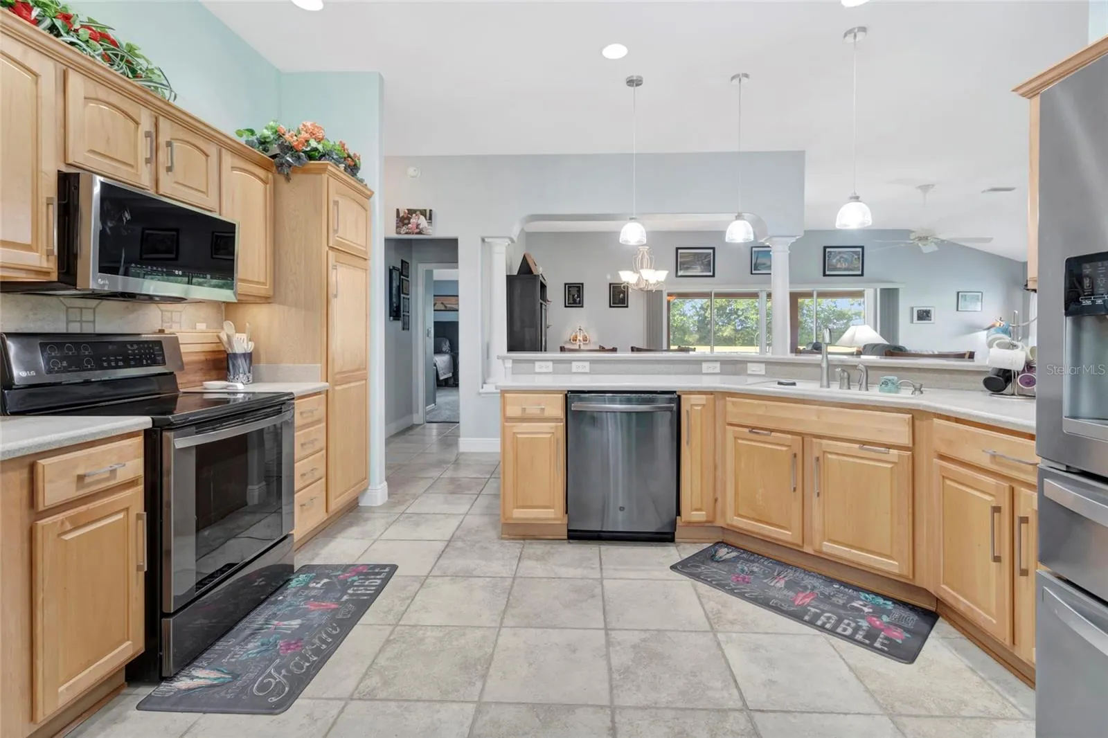 Beautifully lit eat in bar area around the large kitchen area with tile floors.