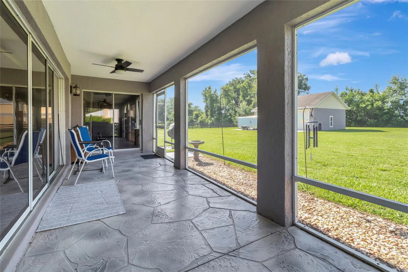 Large outdoor lanai off the back of this home overlooking the large 1-acre estate.