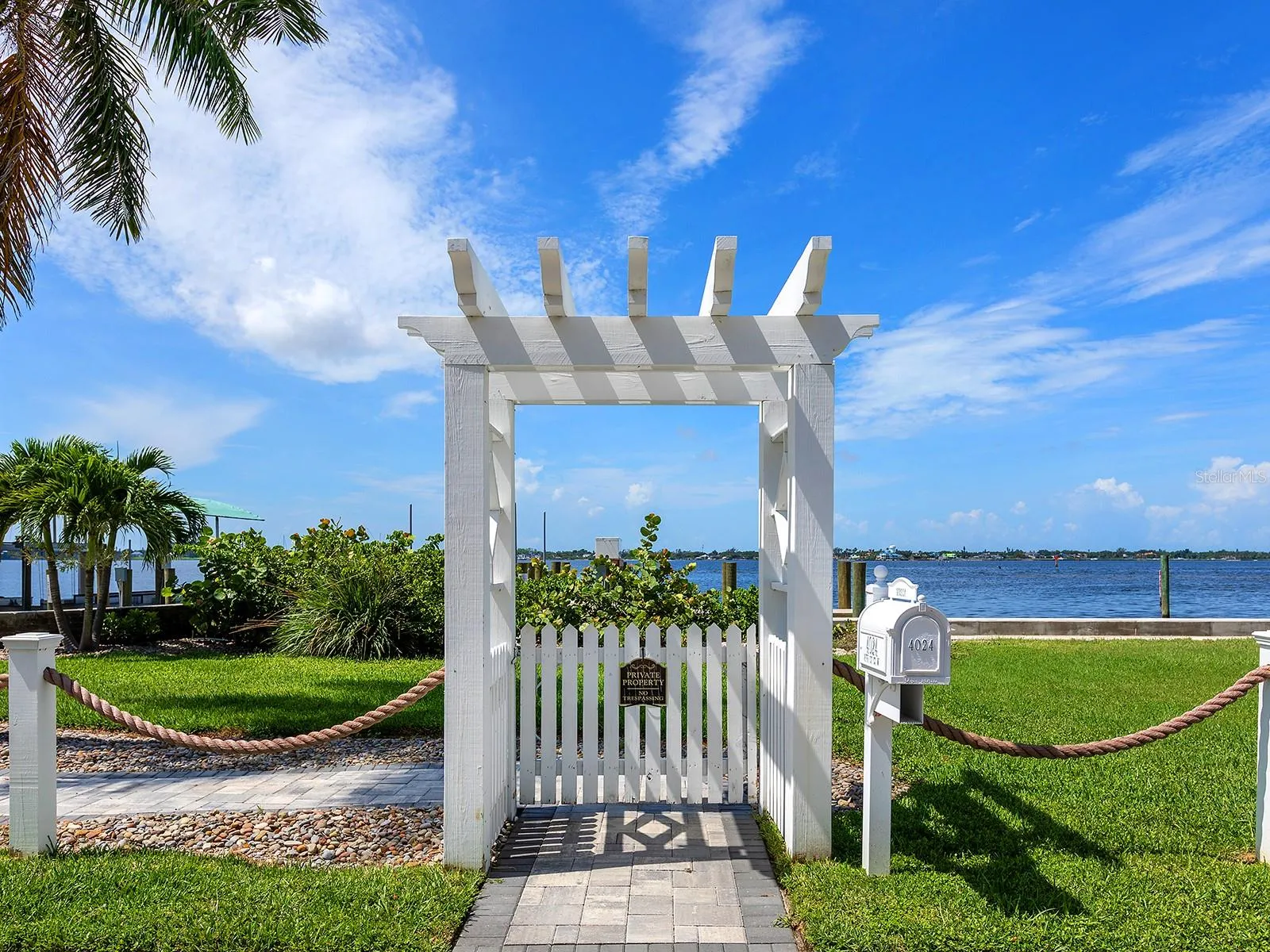 Arbor across the road from the home brings you to a paver terrace and a new 38-foot deeded dock with a boat lift beside a a brand-new, elevated seawall