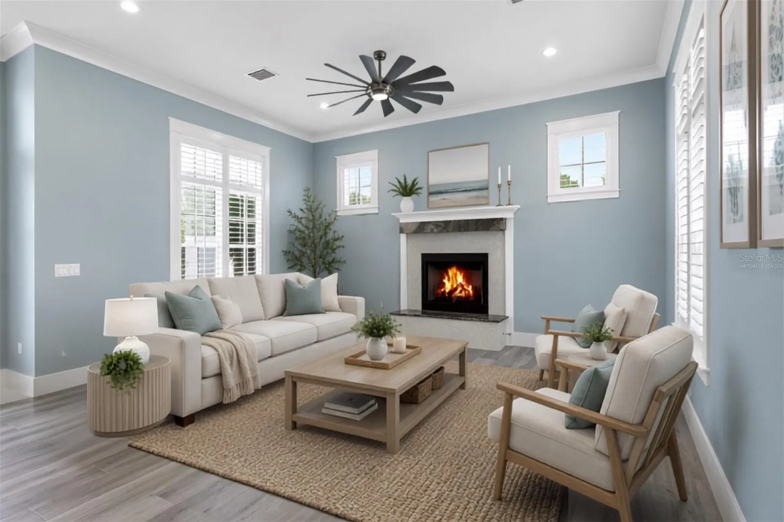Virtually staged ground floor living space . A light-filled retreat with plantation shutters centered around a custom granite gas fireplace, perfect for unwind-and-relax evenings.