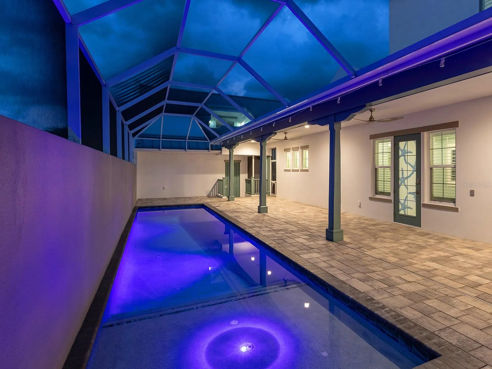 38-foot heated saltwater pool with self-cleaning system, app-controlled lighting, and direct deck access to the ground-floor primary suite