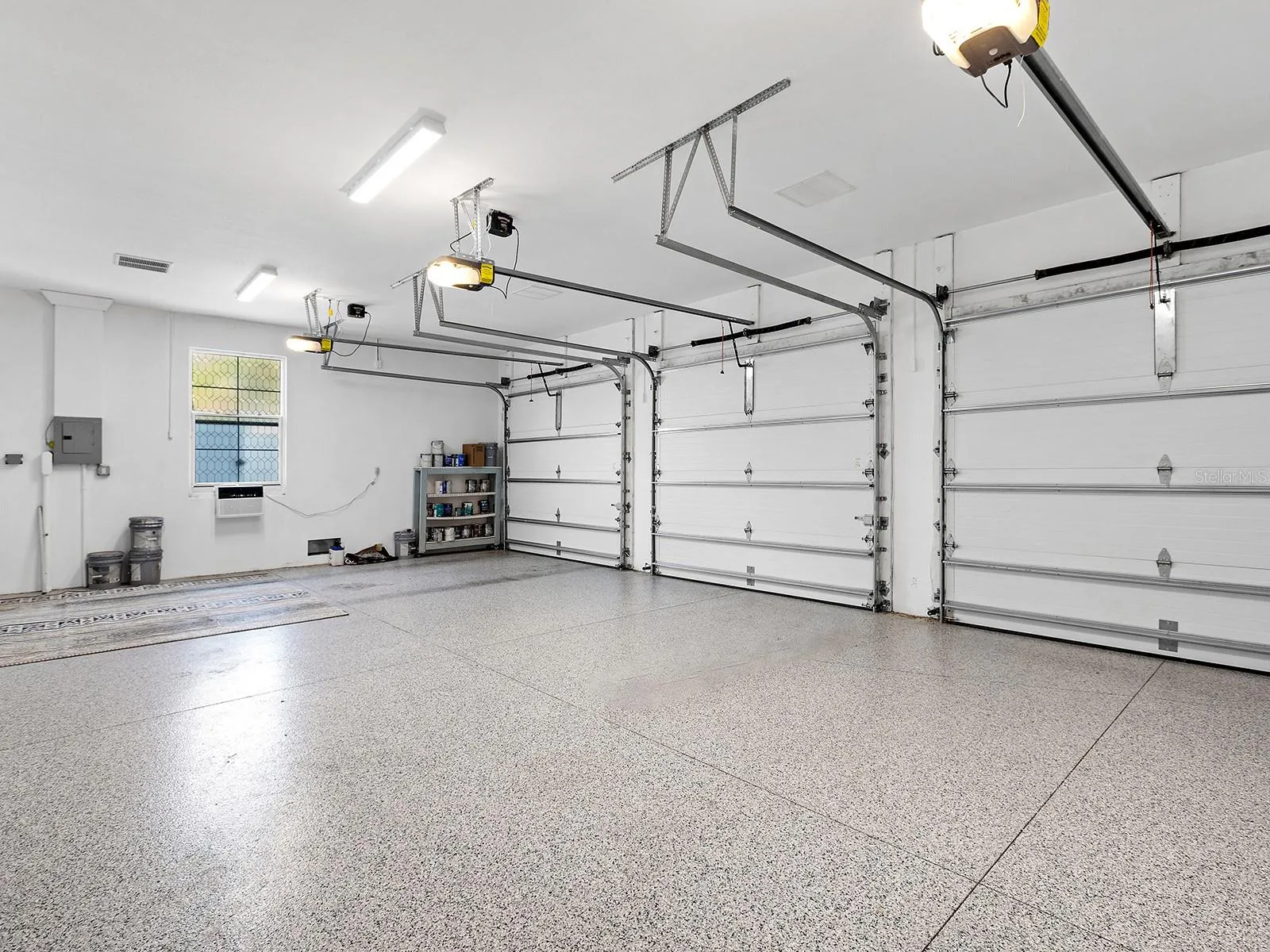 Oversized multi-car garage with epoxy flooring, high clearance for equipment, and built-in storage potential