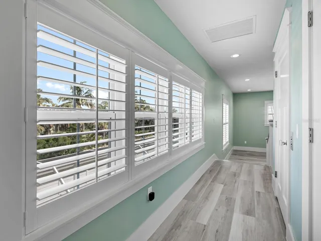 Hallway from the den and primary suite with elevator on right