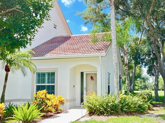 FRONT ENTRANCE TO CONDO WITH A VIEW OF THE WATER AND 4TH GREEN FROM BACK ENCLOSED LANAI.
