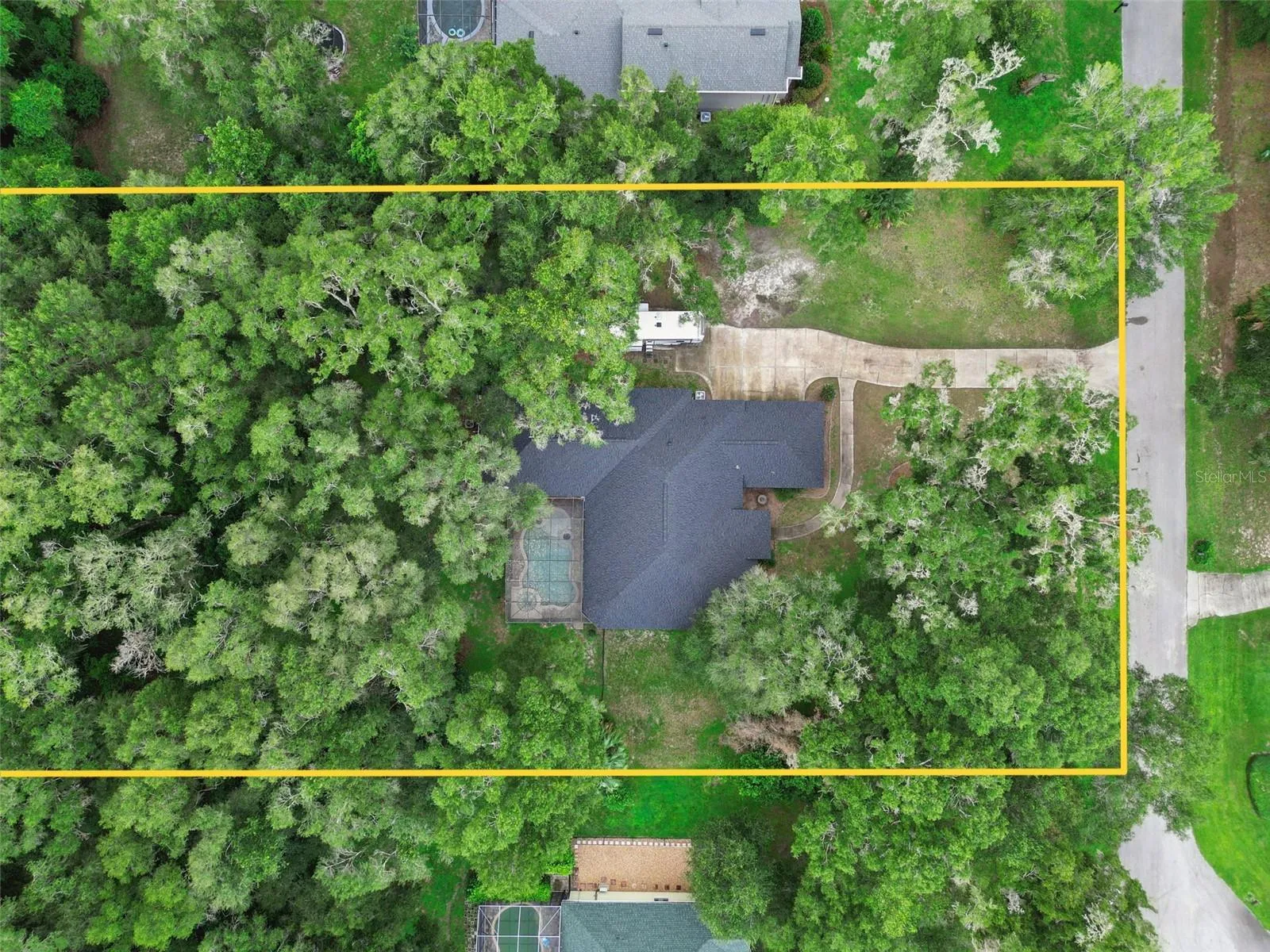 Overhead aerial provides perspective on the home, pool enclosure and surrounding land.