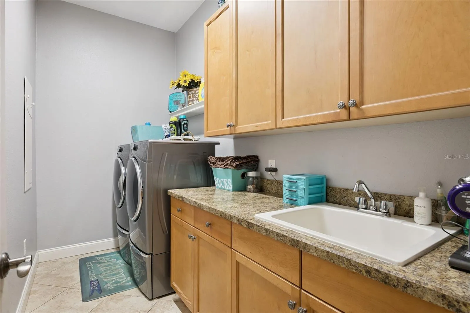 Separate laundry room includes cabinetry, utility sink and additional storage.