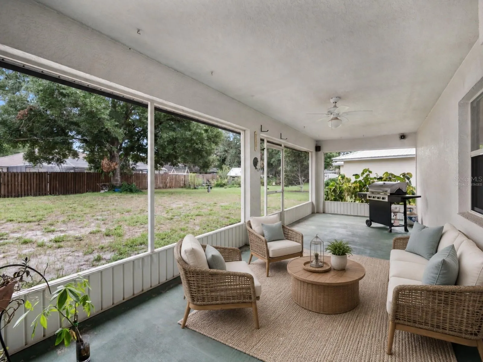 Large screened in patio area, overlooking the backyard - Virtually Staged to enhance experience.