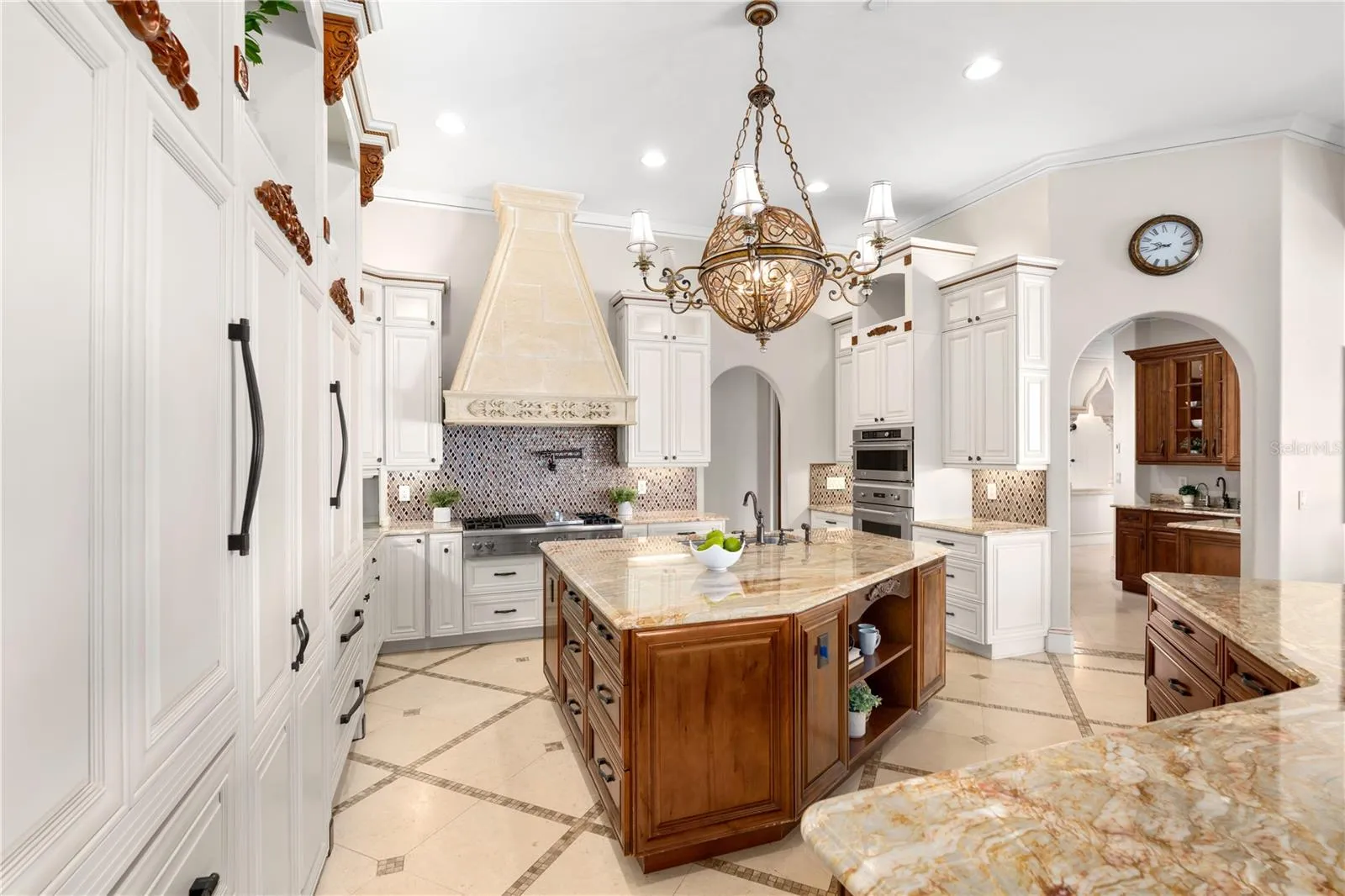 A culinary showpiece featuring extensive custom cabinetry and two Sub-Zero 36-inch built-in, bottom-freezer refrigerators.