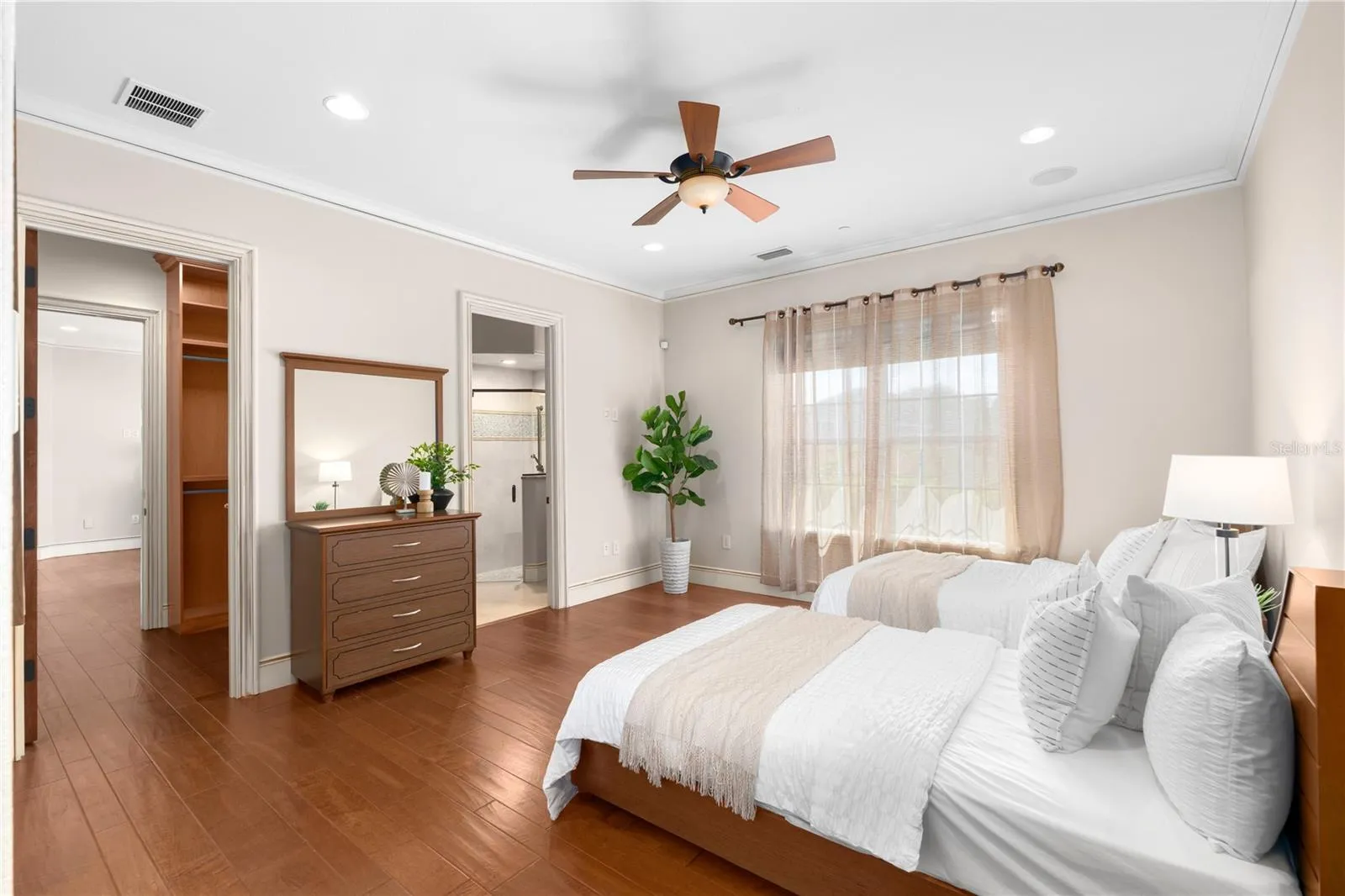 Another view of this generously scaled third bedroom highlights the hardwood flooring, tray ceiling and private en-suite bath offering refined accommodations.