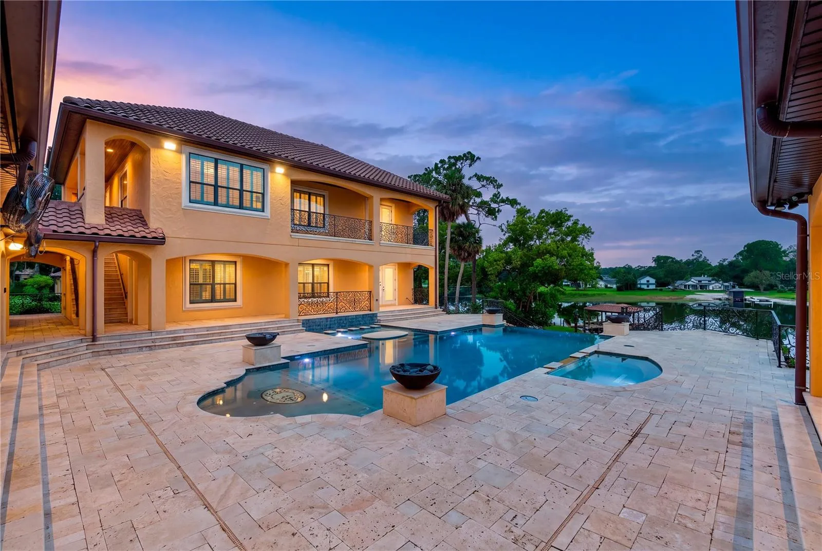 An extraordinary waterfront setting where the infinity-edge pool and spa flow visually toward sweeping views of Lake Mary.