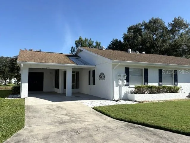 Lovely home with carport, driveway, and golf cart parking both inside and out.