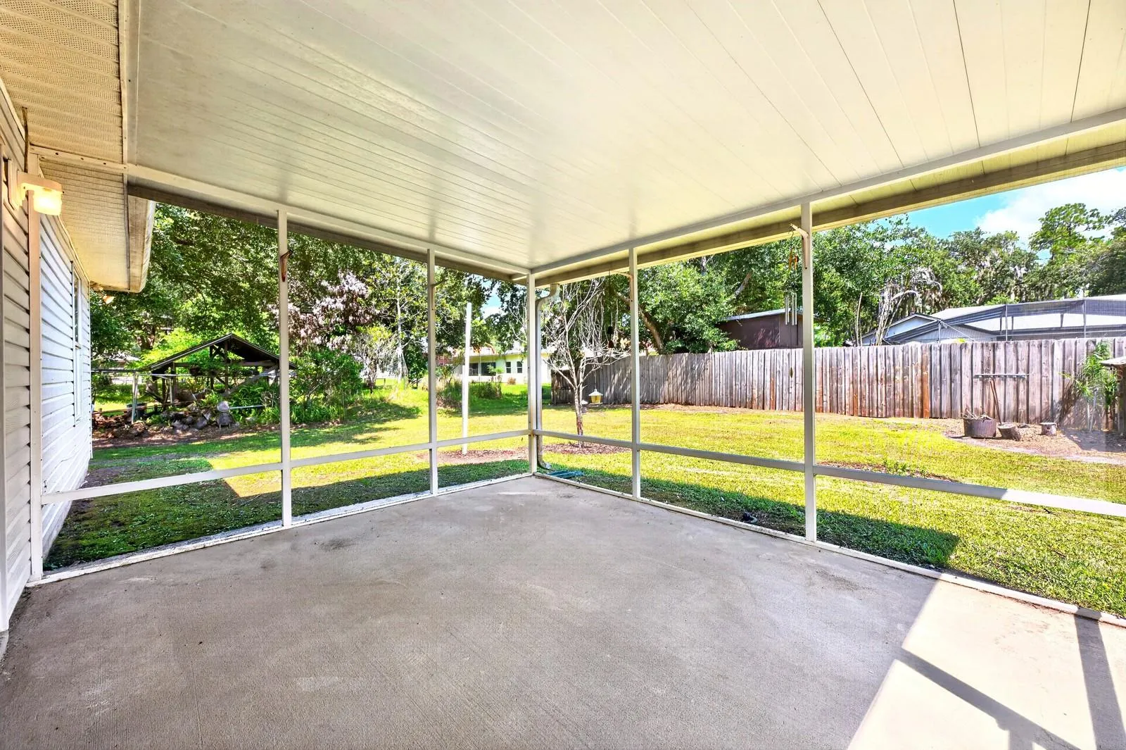 Outside, the covered and screened porch provides a comfortable spot to enjoy the GENEROUS BACKYARD.