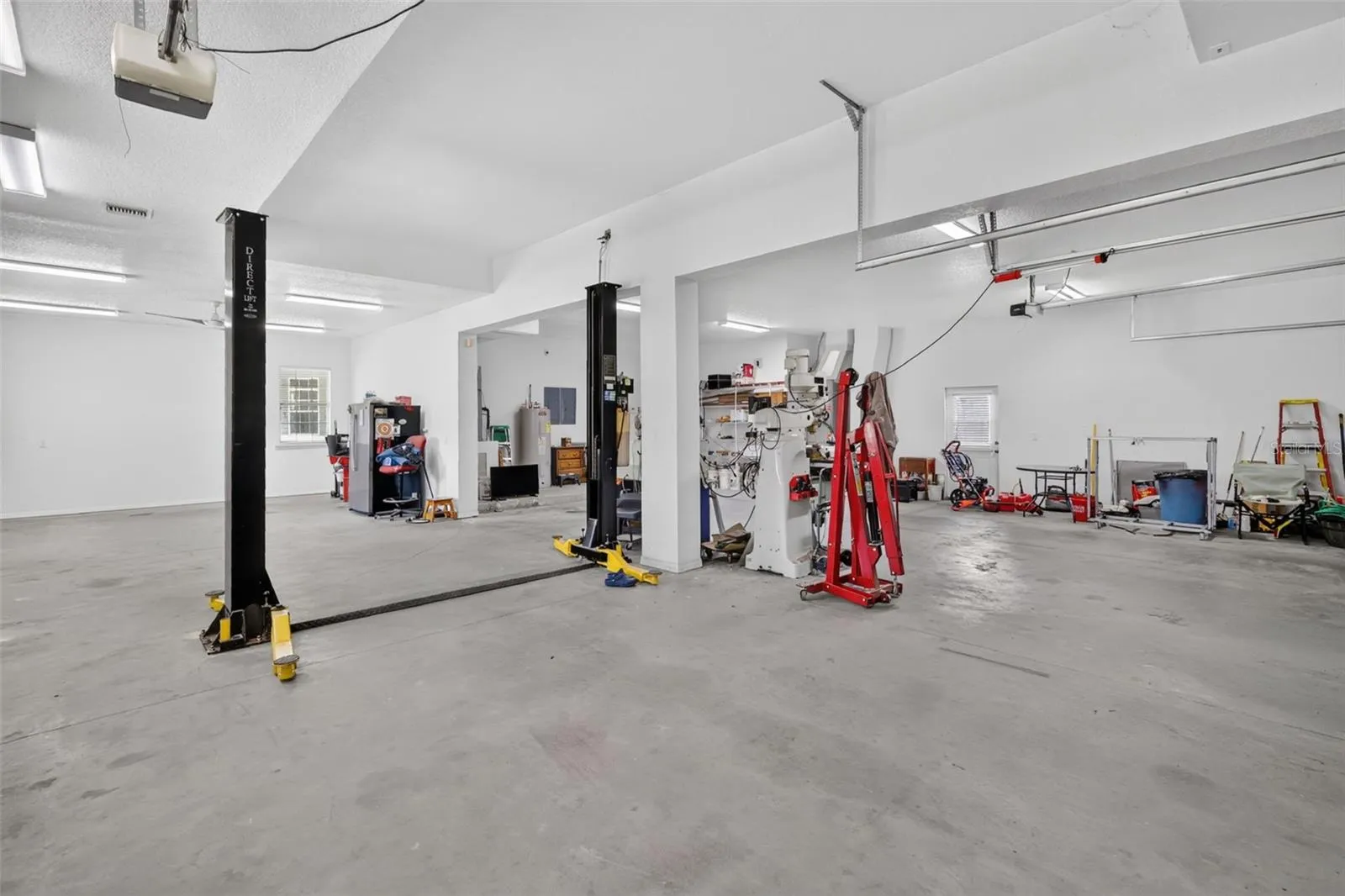 Car enthusiasts and hobbyists, take note: the detached outbuilding features a professional two-post car lift, soaring ceilings, and room for serious projects.
