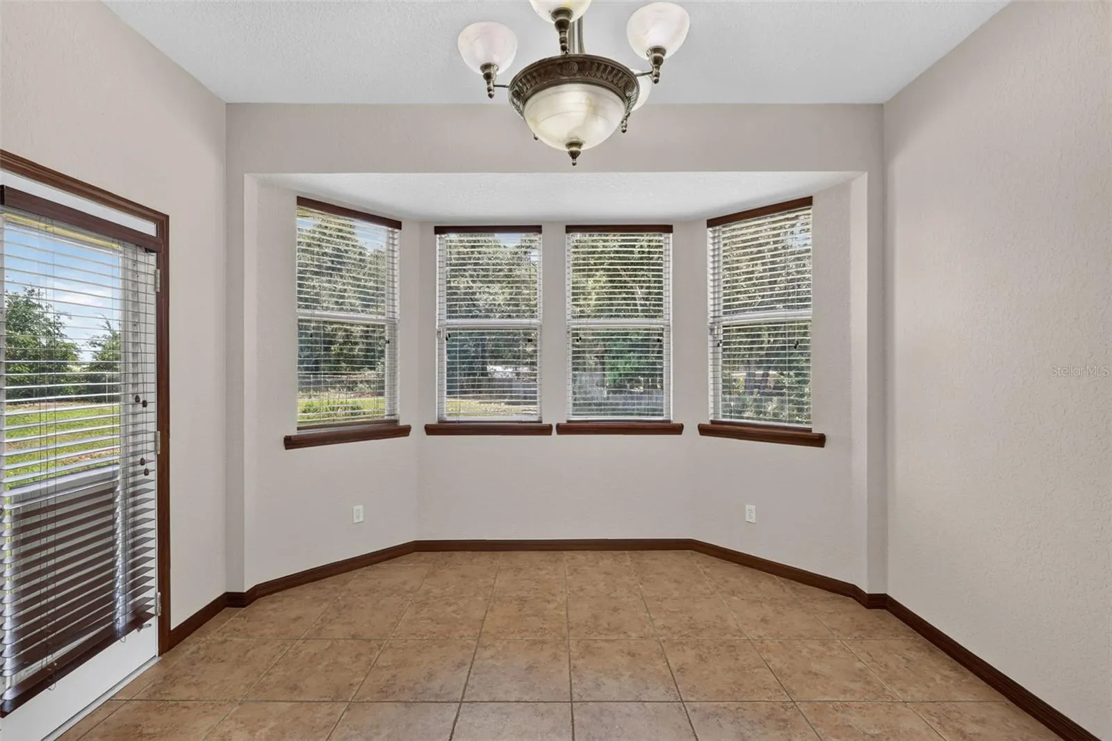 A charming breakfast nook bathed in natural light from a beautiful bay window, with direct access to the outdoors.