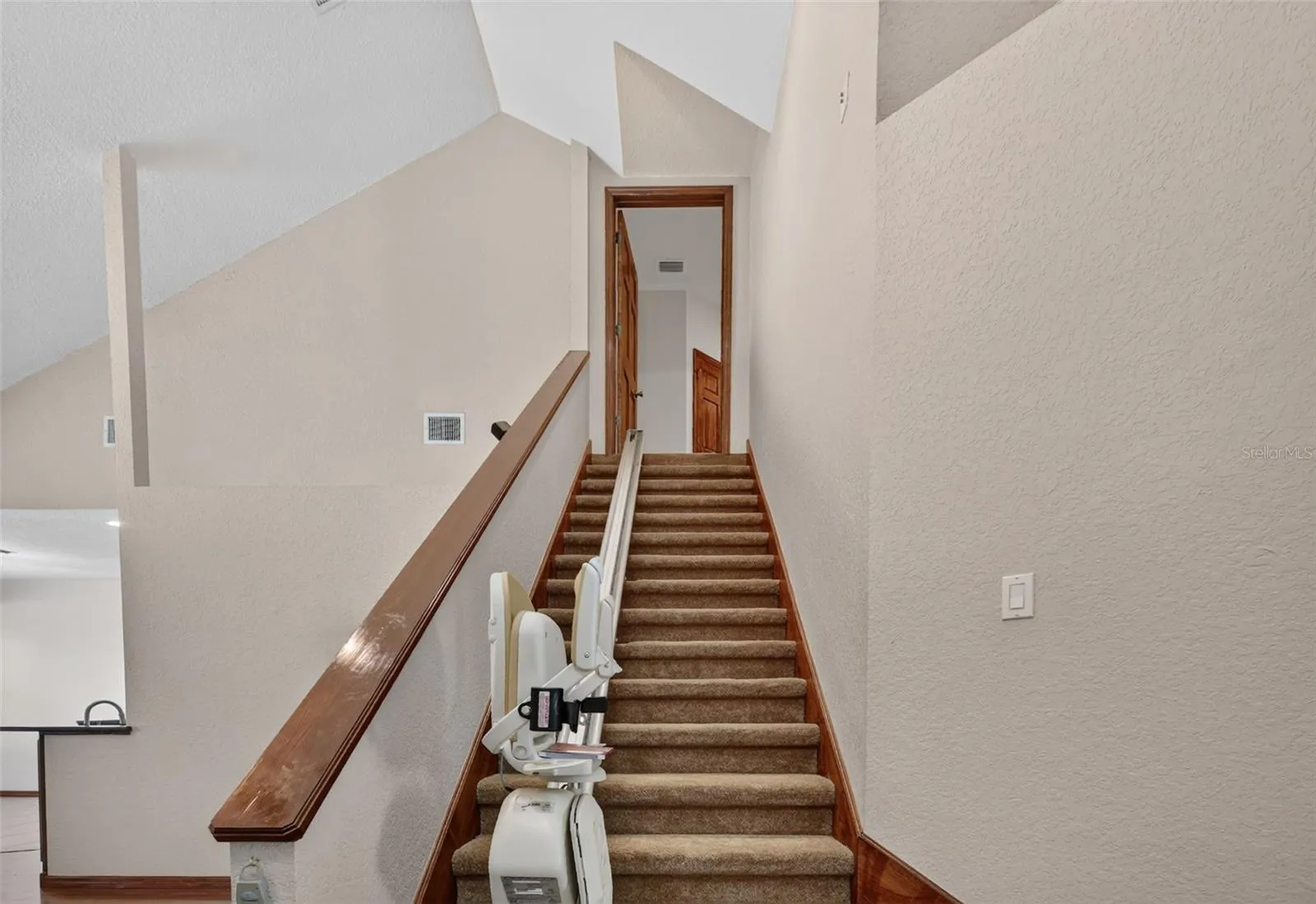 A wide staircase with a convenient stair lift connects the two levels, ensuring easy access for everyone in the household.