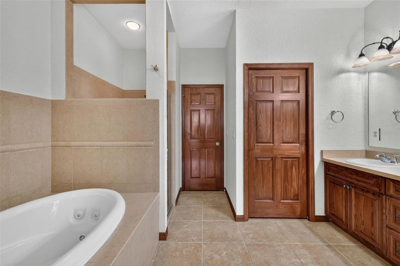 This spa-like primary bathroom has room to breathe, with a jetted tub, separate shower, and plenty of storage.