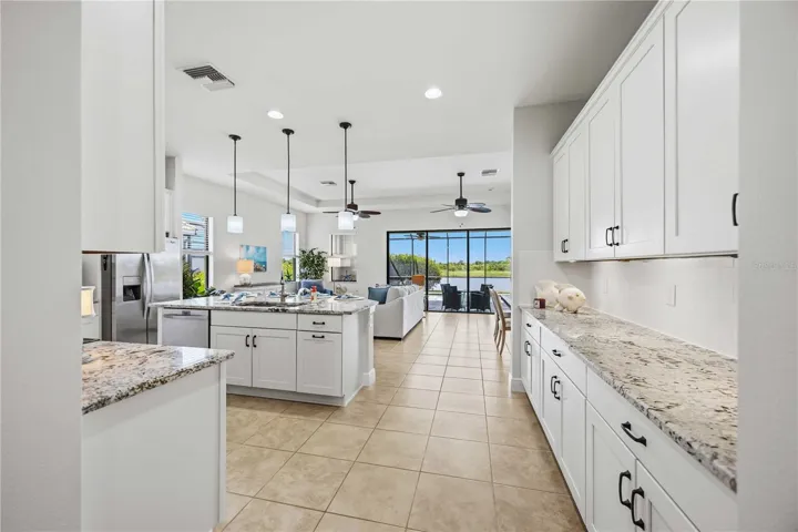 The kitchen is a showpiece - stunning pendant lights, white cabinets and granite counter tops.
