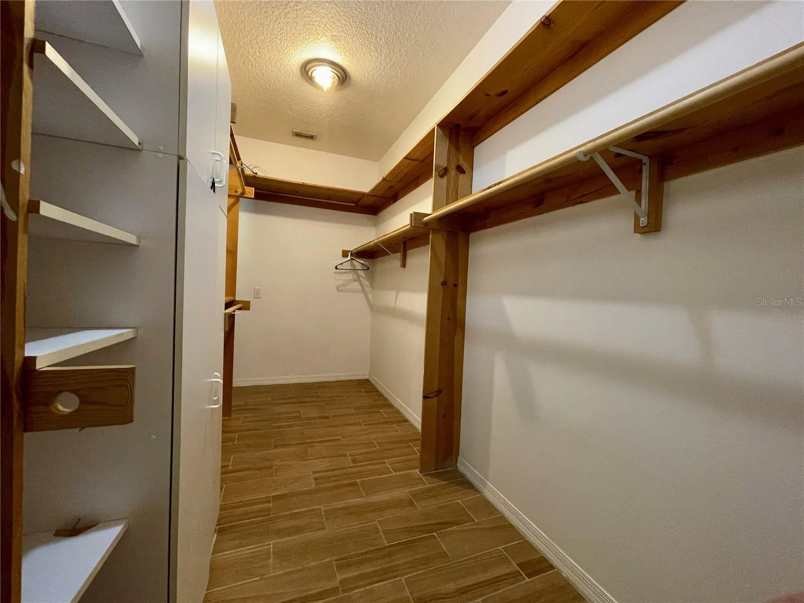 Generously sized walk-in closet provides extensive hanging space, built-in shelving, and additional room for organized storage.