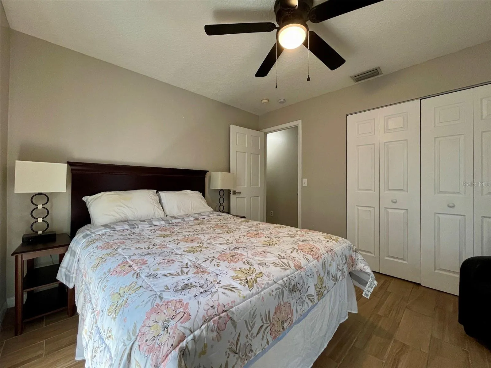 Another angle highlights the bedroom’s double closet, ceiling fan, and flexible floor space.