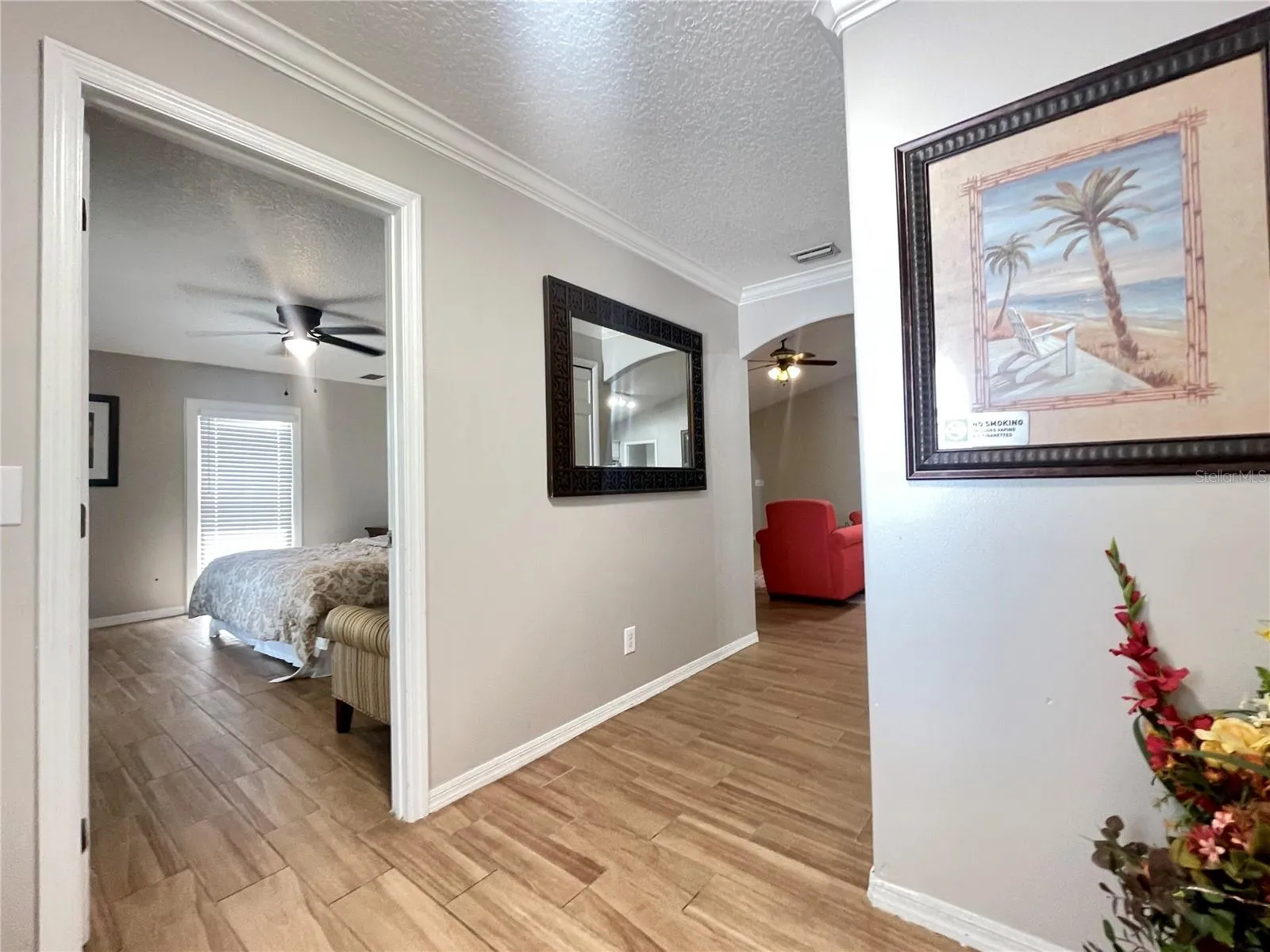 The entry opens to a neutral interior with crown molding, arched architectural details, and an easy flow toward the main living spaces and bedroom.