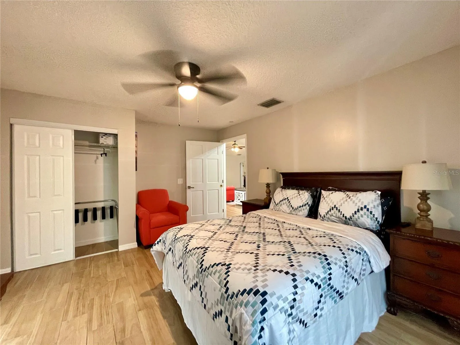 An additional view highlights the bedroom’s comfortable proportions, ceiling fan, and closet storage.