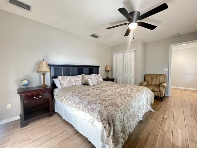 An additional angle showcases the room’s generous proportions, ceiling fan, and closet storage.