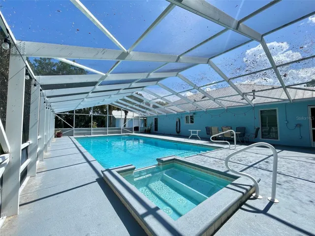 Another view showcases the large screened pool, and broad surrounding deck with space for lounging and entertaining.